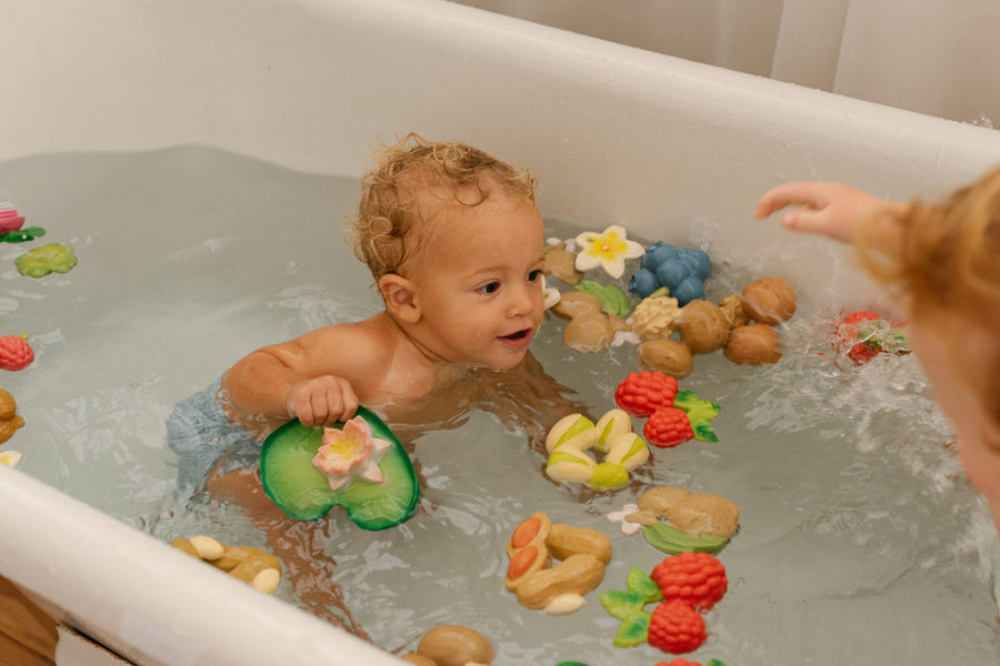 Child playing in a bath with the oli and carol natural rubber