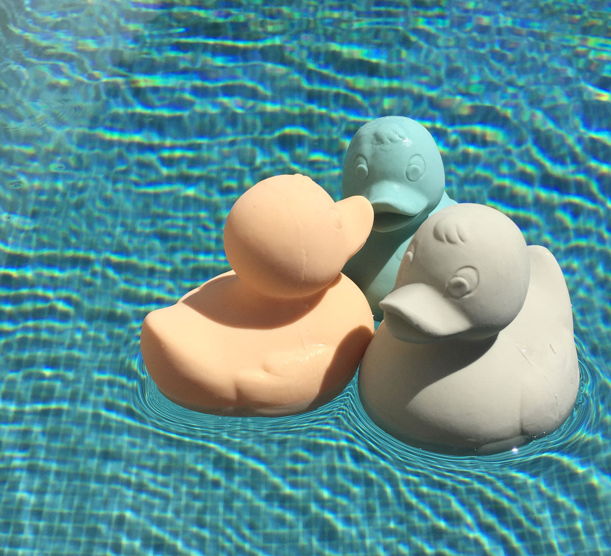 Three Oli & Carol Elvis The Duck Bath Toys floating in a swimming pool