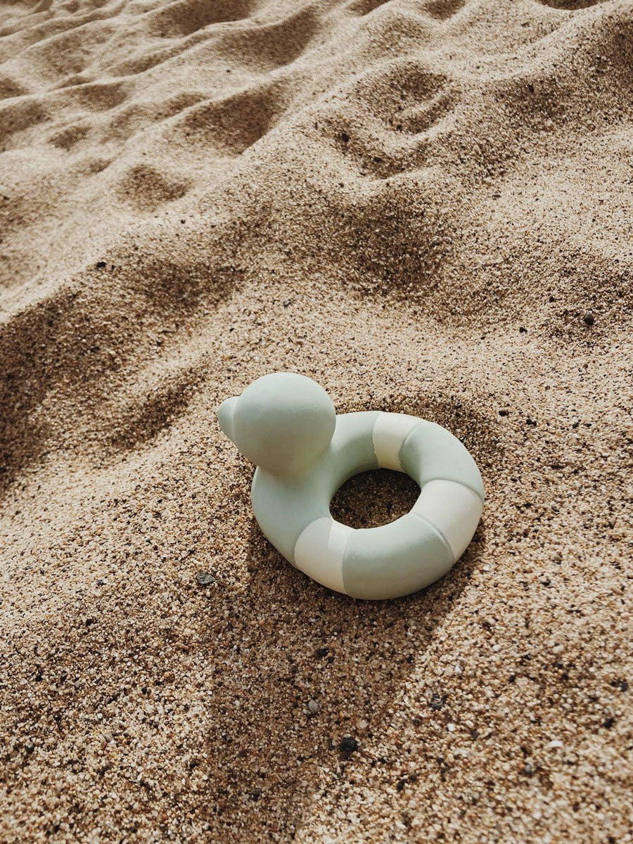 Oli & Carol Flo The Floatie Mint colour duck pictured on sand