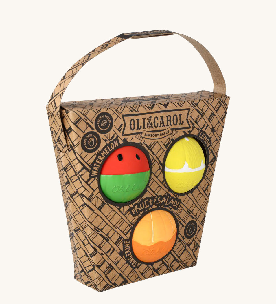 Oli & Carol Fruit Salad Baby Sensory Balls including a watermelon, lemon and tangerine in their cardboard basket shaped packaging