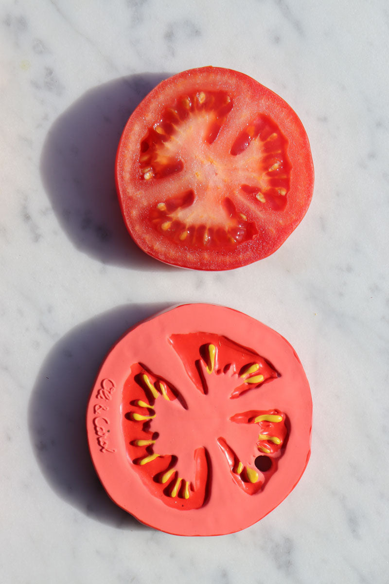 Oli & Carol Renato The Tomato pictured next to a slice of real tomato on a marble surface