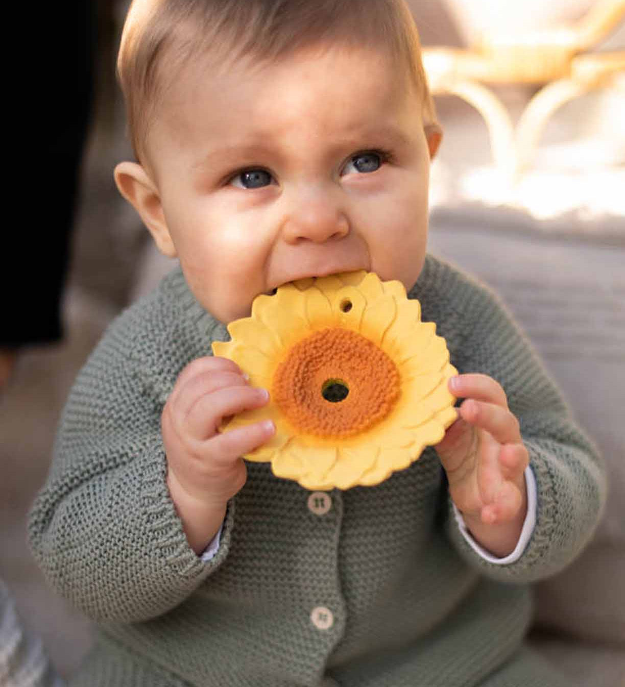 A baby chewing on the Oli & Carol Sun The Sunflower Baby Teether