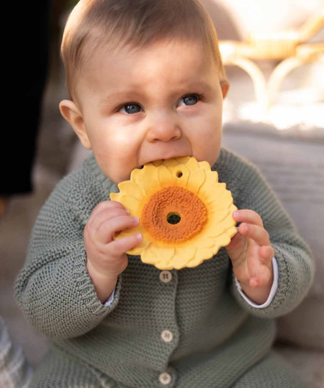 A baby chewing on the Oli & Carol Sun The Sunflower Baby Teether