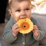 A baby chewing on the Oli & Carol Sun The Sunflower Baby Teether