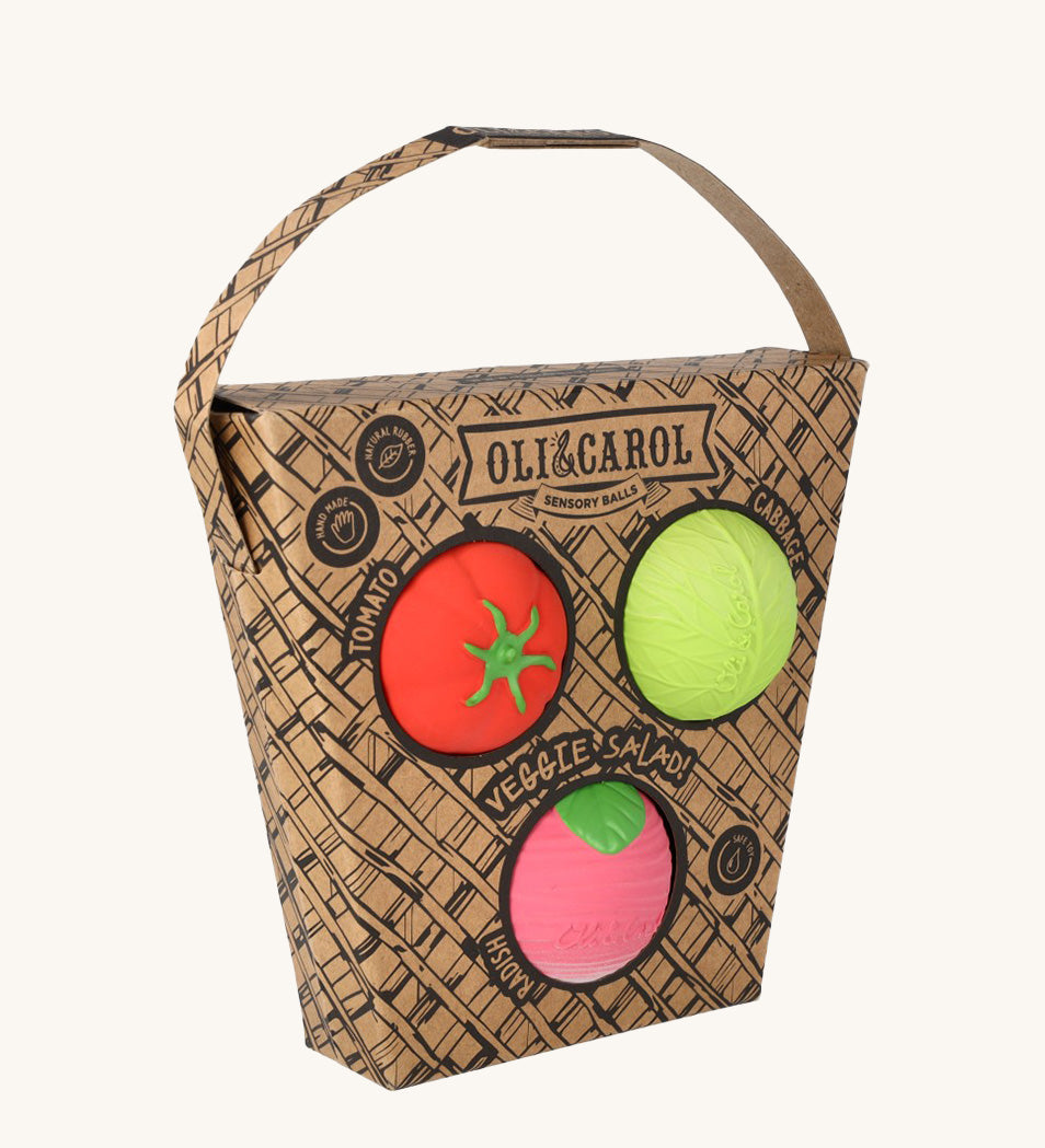 Oli & Carol Veggie Salad Baby Sensory Balls in their basket shaped cardboard packaging, a tomato, cabbage and a radish