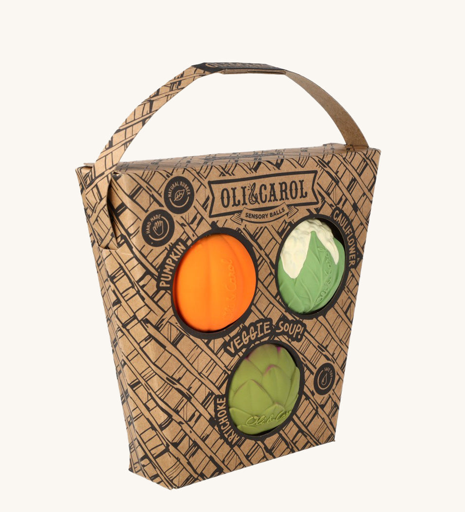 Oli & Carol Vegetable soup Baby Sensory Balls in their basket shaped cardboard packaging, a pumpkin, cauliflower and an artichoke. 