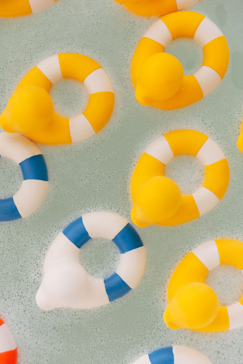 Yellow coloured Oli & Carol Flo The Floatie Ducks in bubbly bath water