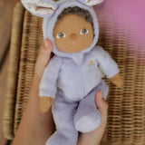 A close up of an Olli Ella purple coloured Babs Bunny Dinky Dinkum Doll in a child's hands.