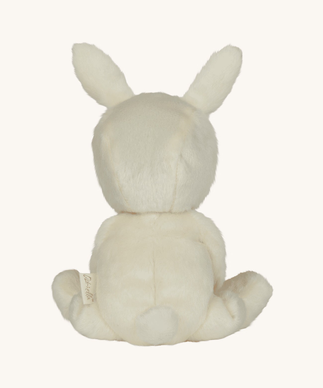 Olli Ella cream coloured Basil Bunny Dinky Dinkum Doll in a seated position facing away from the camera showing the back of the teddy.