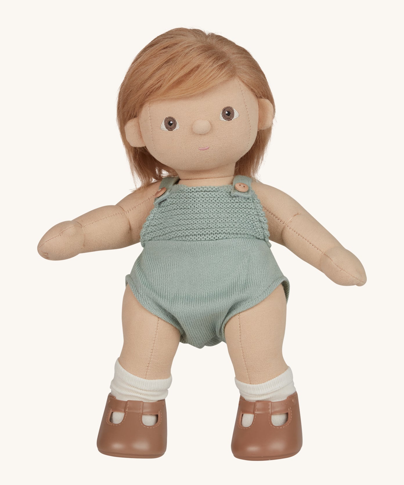 An Olli Ella Gigi Dinkum doll. The doll has blonde hair worn down and brown eyes. The doll is in a standing position and is wearing a mint green coloured knitted outfit and light brown coloured shoes. Shown on a plain background.  