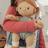 A close up of a child holding an Olli Ella Gigi Dinkum doll.