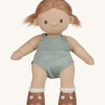 An Olli Ella Gigi Dinkum doll. The doll has blonde hair in pig tails and brown eyes. The doll is in a standing position and is wearing a mint green coloured knitted outfit and light brown coloured shoes. Shown on a plain background.  