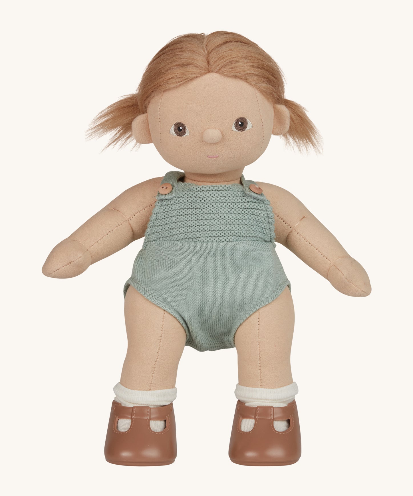 An Olli Ella Gigi Dinkum doll. The doll has blonde hair in pig tails and brown eyes. The doll is in a standing position and is wearing a mint green coloured knitted outfit and light brown coloured shoes. Shown on a plain background.  