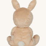 Olli Ella light sand coloured Bubba Bunny Dinky Dinkum Doll in a seated position facing away from the camera. The back of the dolly can be seen with a white fluffy tail on. 
