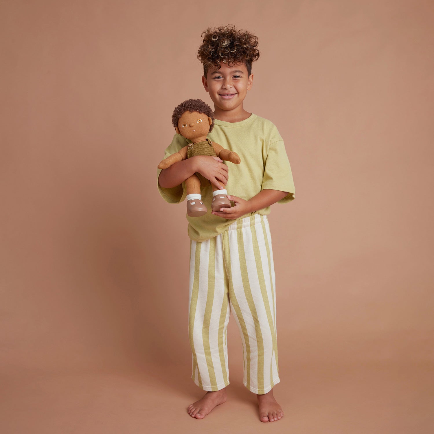 Dinkum Doll sitting down pictured on a plain coloured background