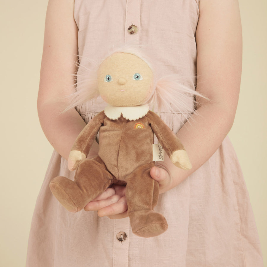 Close up of a child holding an Olli Ella brown dinky doll soft toy