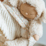 A close up of the Lamby Picket Olli Ella Cozy Dinkum Doll in a toy carrier. 