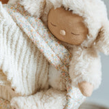 A close up of the Lamby Picket Olli Ella Cozy Dinkum Doll in a toy carrier. 