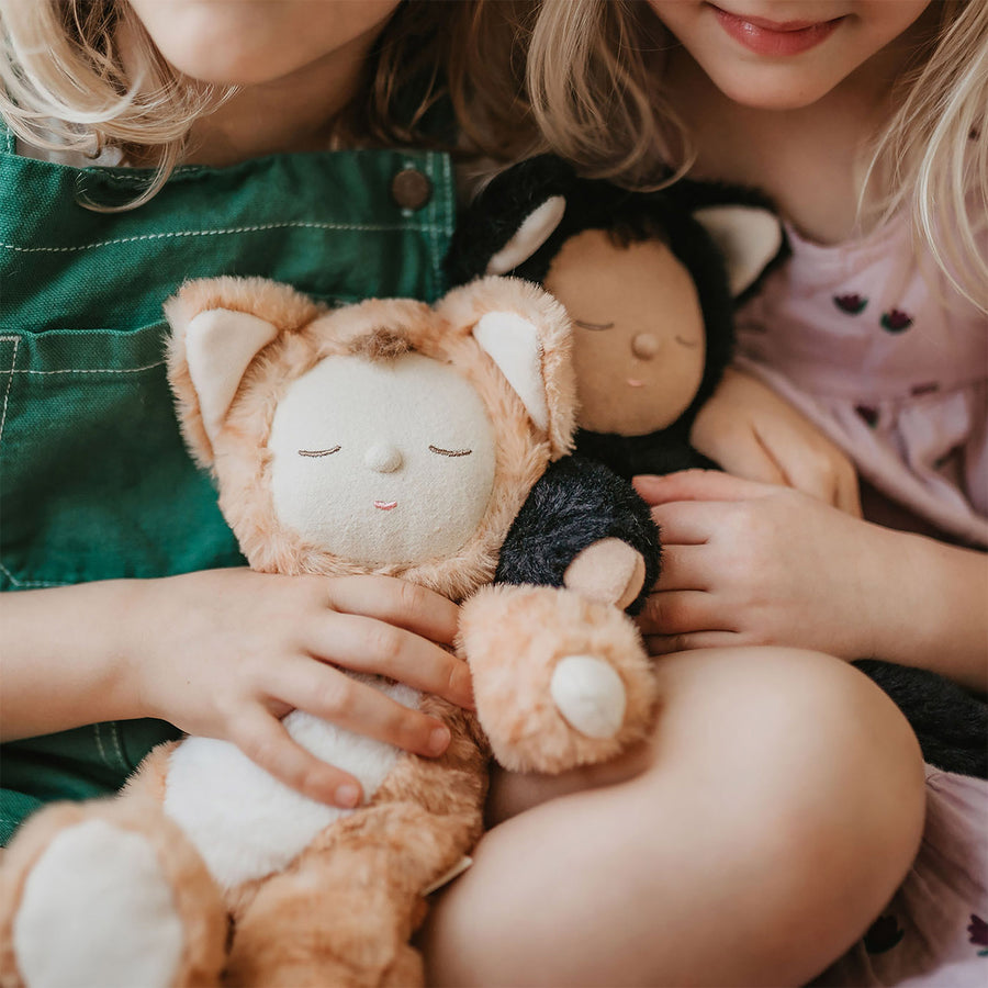 Olli Ella Cozy Dinkums - Tabby Cat Jinx and Black Cat Nox sit on the laps of two children. The children snuggle the toys.