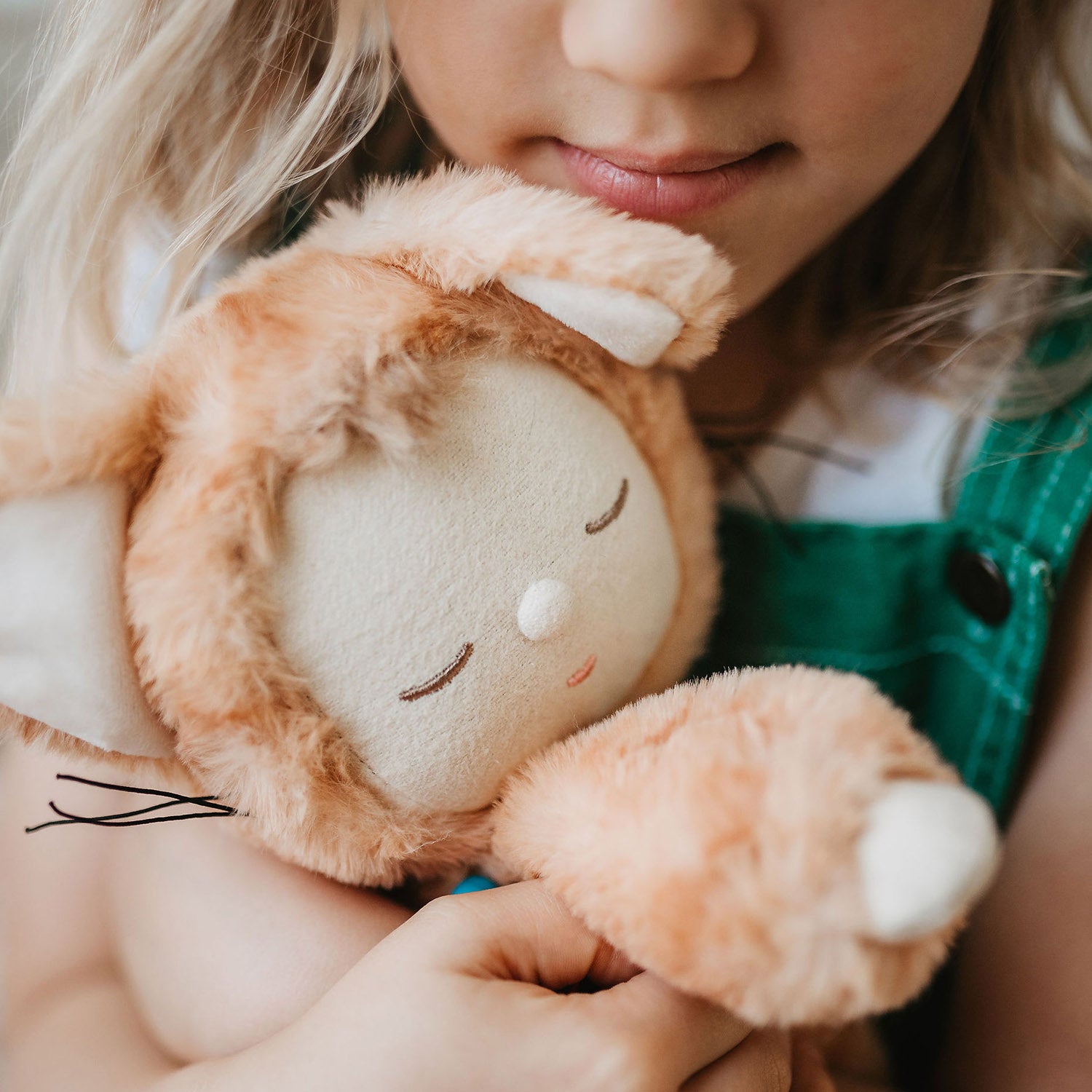 the young girl cuddles the toy.