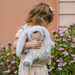 A child carrying the Olli Ella Bunny Lala Cozy Dinkum in a Olli Ella toy carrier. 