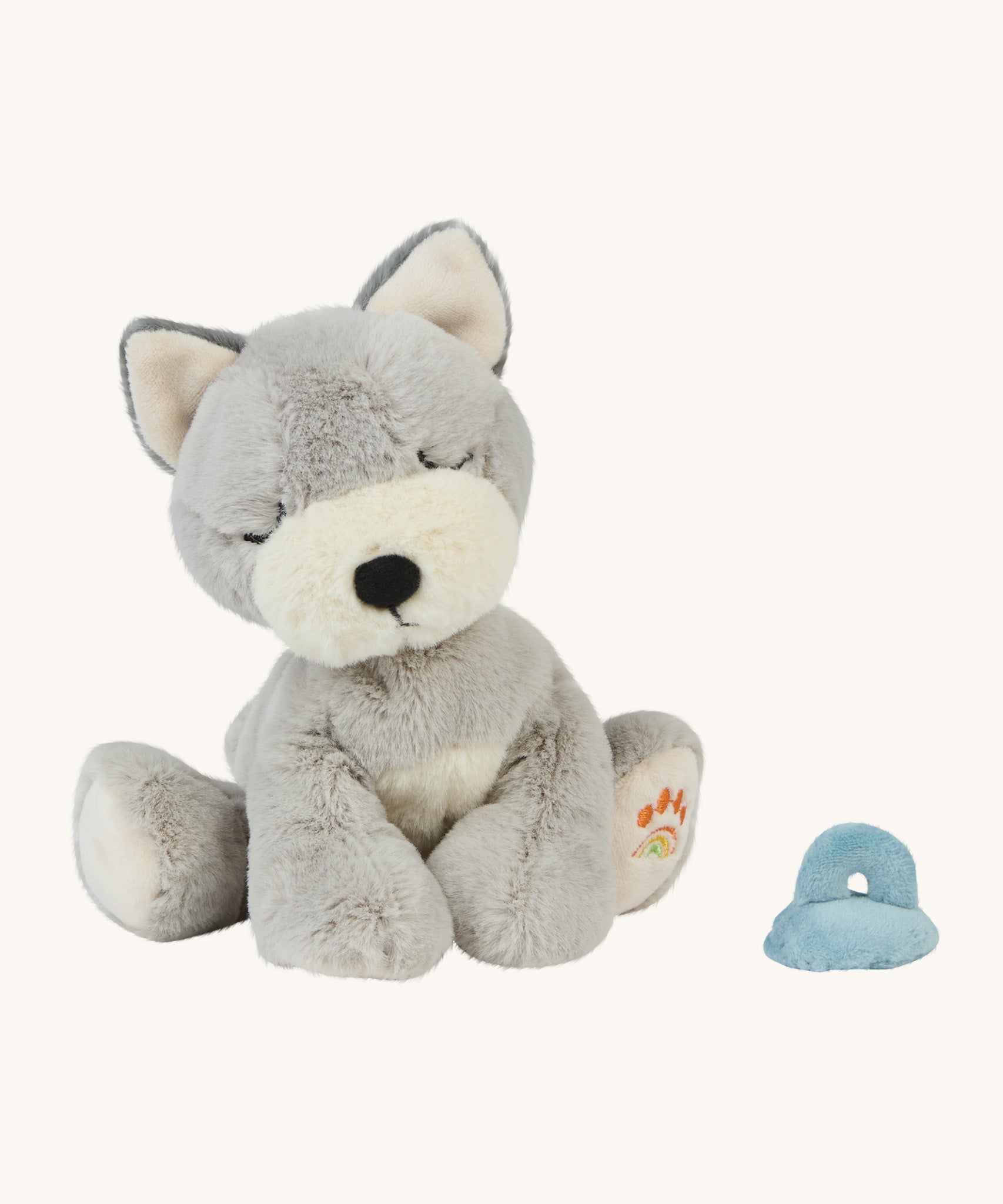 A soft grey and white Olli Ella Dinkum puppy sitting next to a soft magnetic soft toy