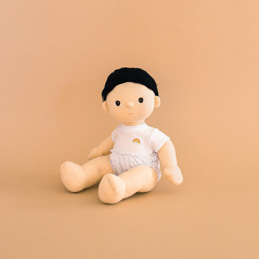 Olli ella childrens dinkum doll toy sat on a brown background wearing the basics toy clothing set