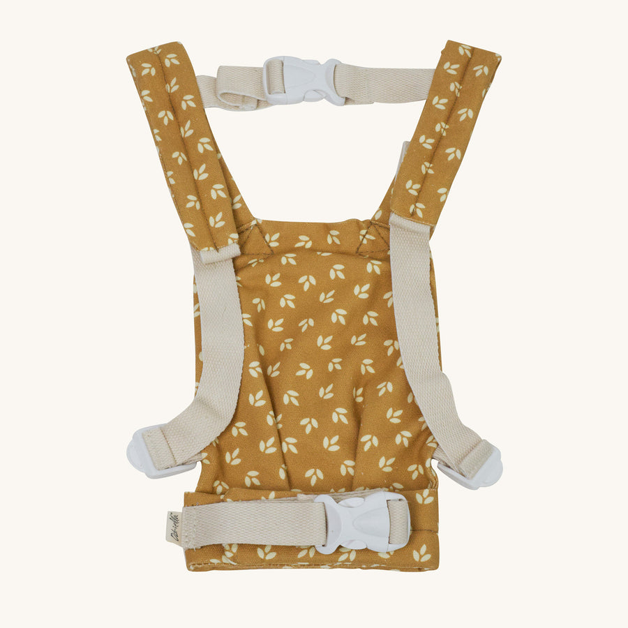 Back of the Olli Ella Dinkum Doll Carrier in a yellow colour with a white Leaf print pictured on a plain background