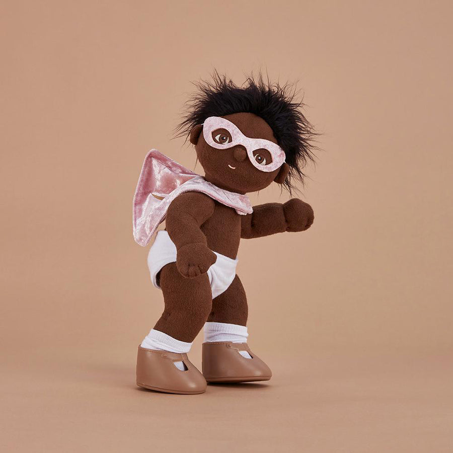 Olli ella dinkum doll stood on a brown background wearing the rose superhero set