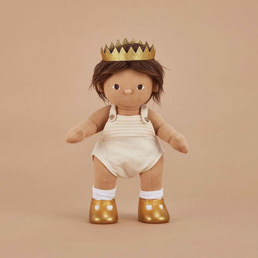 Olli ella dinkum doll stood on a beige background wearing the gold sparkle crown and shoes accessory toy set