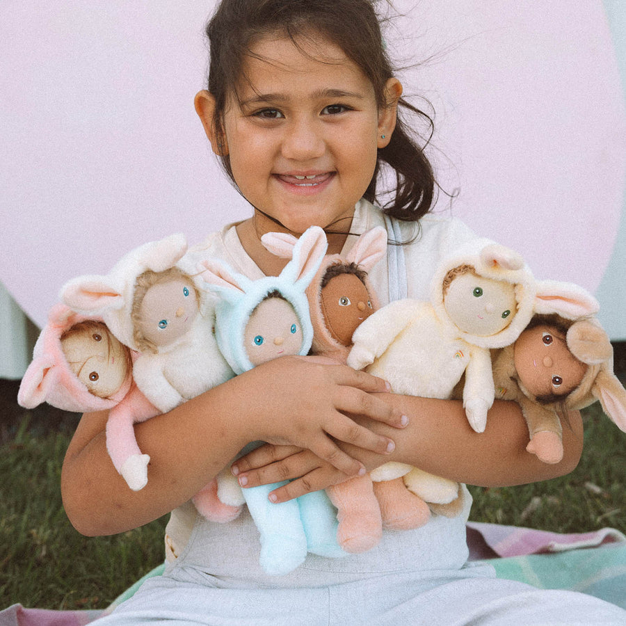 A child happily playing with the Olli Ella Dinky Dinkum Doll Fluffles collection