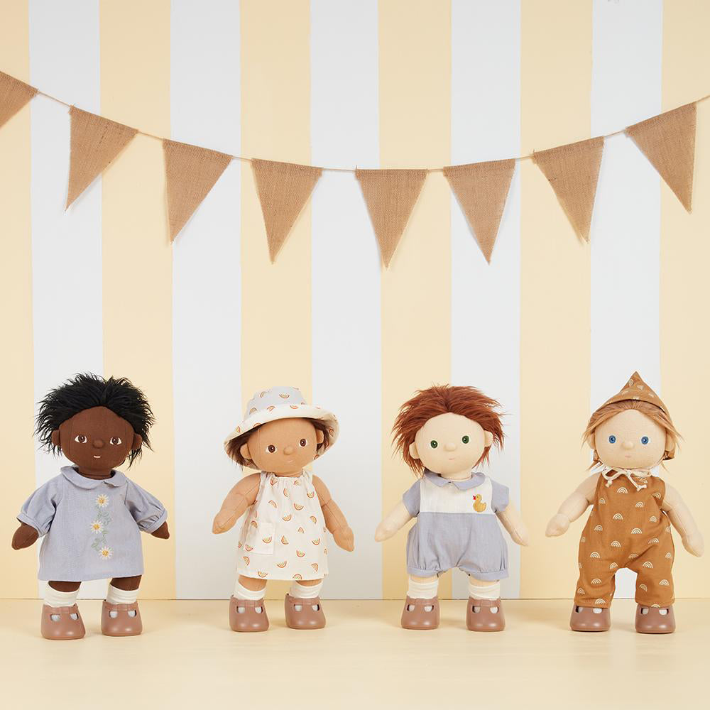 4 Olli Ella dinkum dolls stood in a line wearing dinkum doll outfits on a cream and white striped background