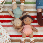 Olli Ella Gigi and Dottie Dinkum Dolls laying on a striped towel. 