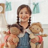 A child holding the Gigi and Dottie Dinkum Dolls. 