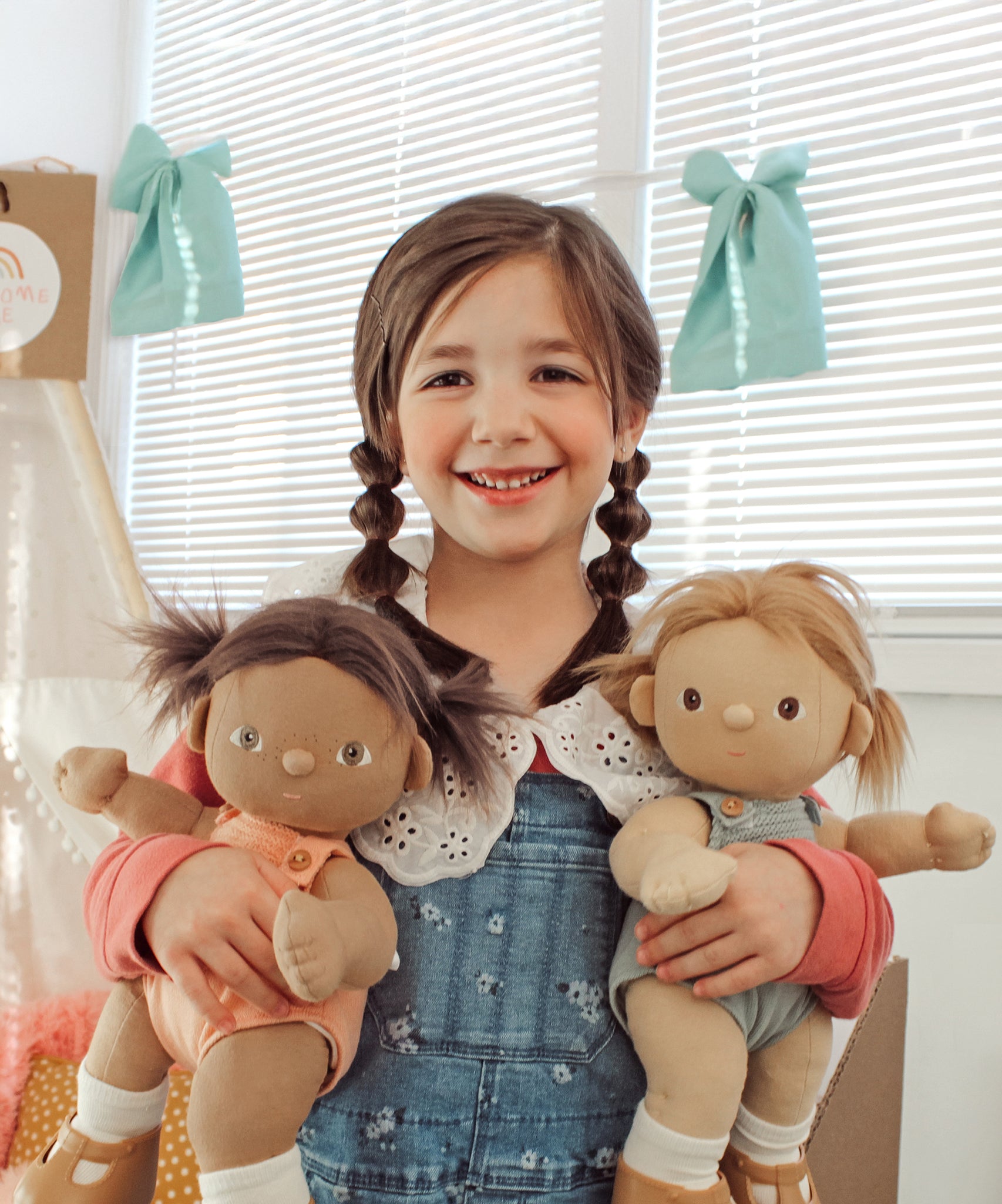 A child holding the Gigi and Dottie Dinkum Dolls. 