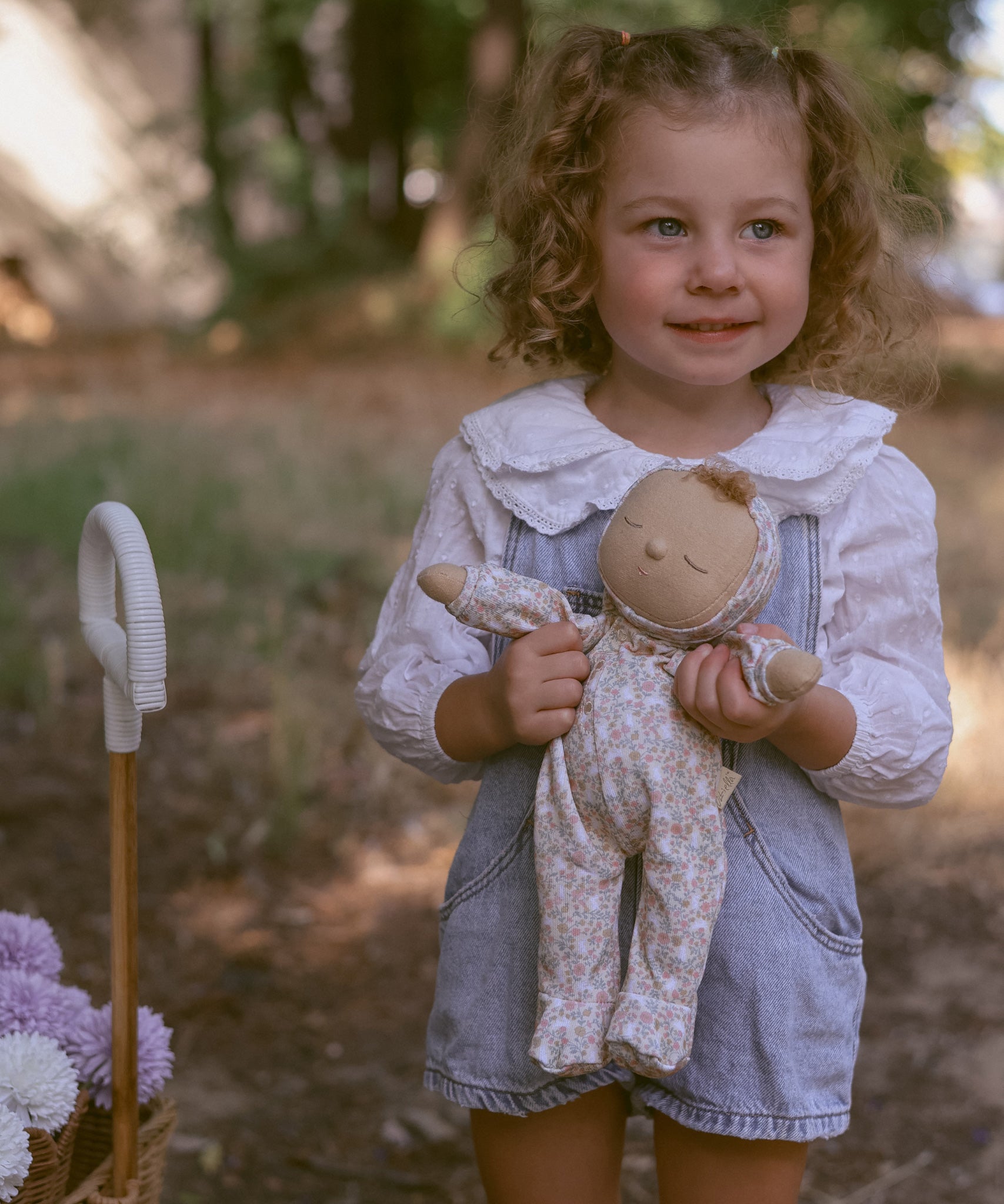 A child holding an Olli Ella Dozy Dinkum Doll Custard.