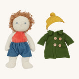 Charlie Chestnut Dress Me Dinky Doll by Olli Ella, wearing denim shorts. The green fleece trench coat, and yellow bobble beanie hat next to him. Cream background. 