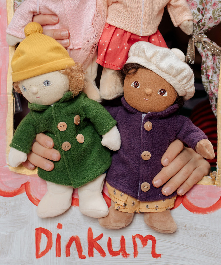 Two Dress Me Dinky dolls in a puppet show being held by a child. 