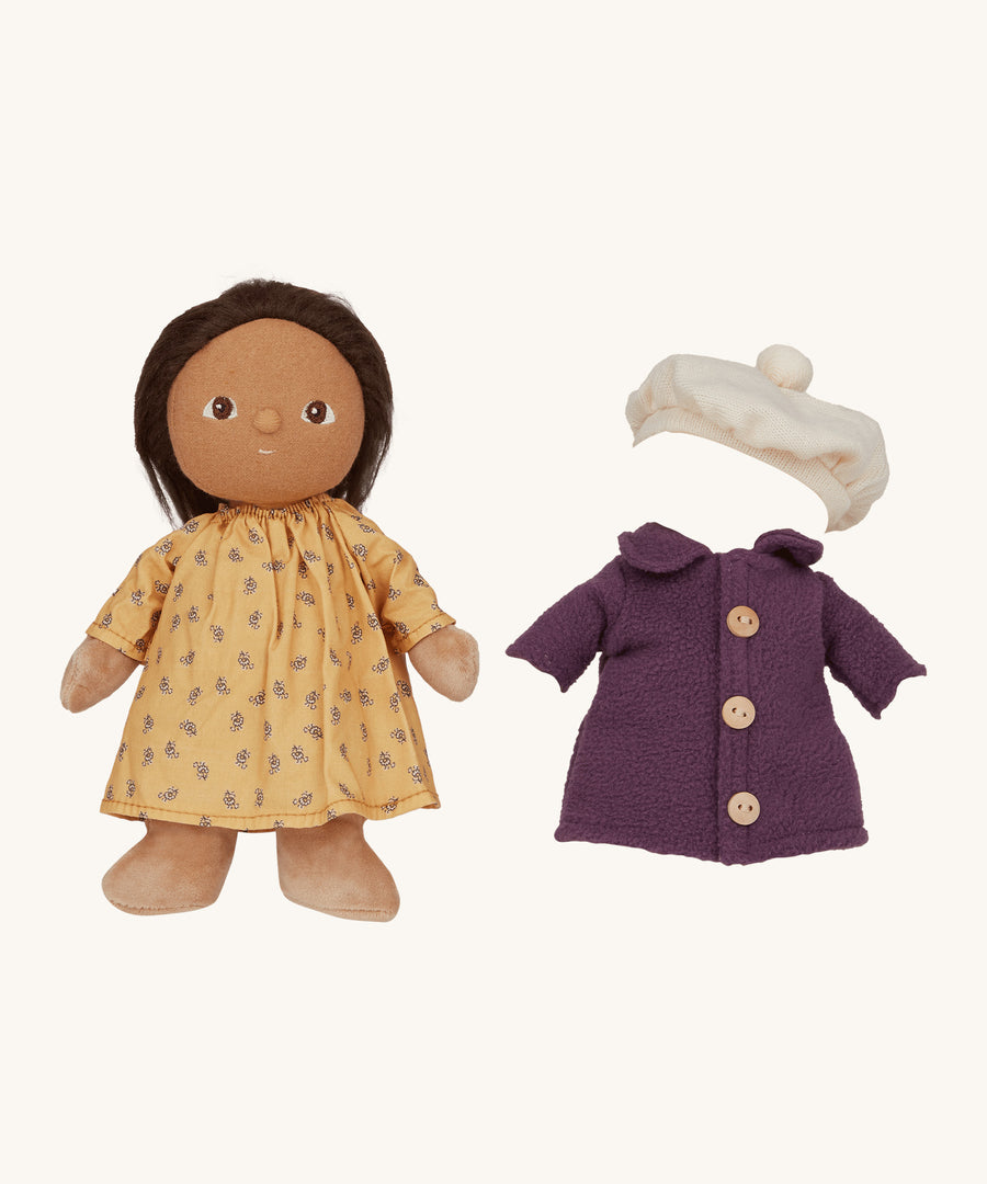 Olli Ella Dress Me Dinky - Lila Lavender wearing a yellow dress with a purple fleece trench coat and white beret beside her. Cream background. 