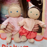 Two Dress Me Dinky dolls in a puppet show being held by a child. 