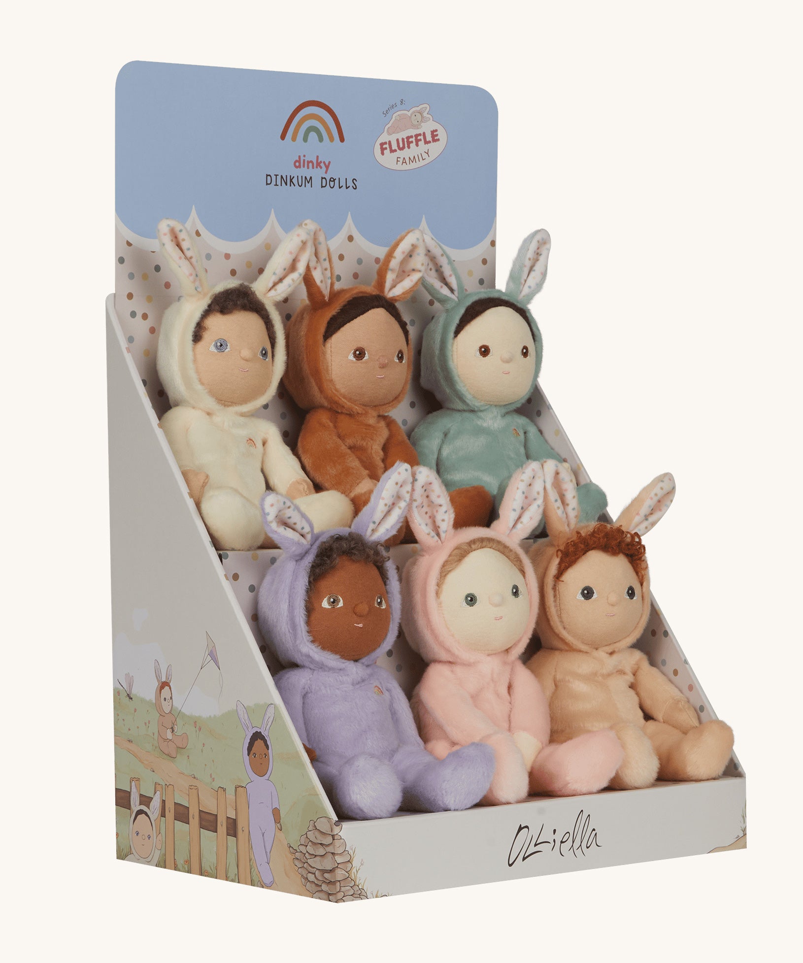 Olli Ella Dinky Dinkum Fluffle Family Bunny Dolls in their cardboard display stand. There are 6 bunnies in total including Babbit, Babs, Basil, Bubba, Biscuit and Bucky. The box is pictured at an angle showing the illustrations of the bunnies on the side of the stand.