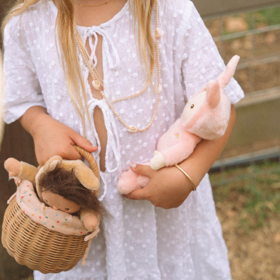 A child cradling Bella Bunny in one arm