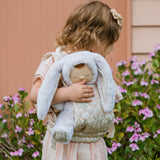 A child carrying a Dozy Dinkum Bunny doll using the Olli Ella Garden Floral Gardenia print Dinkum Dolls Quilted Toy Carrier.