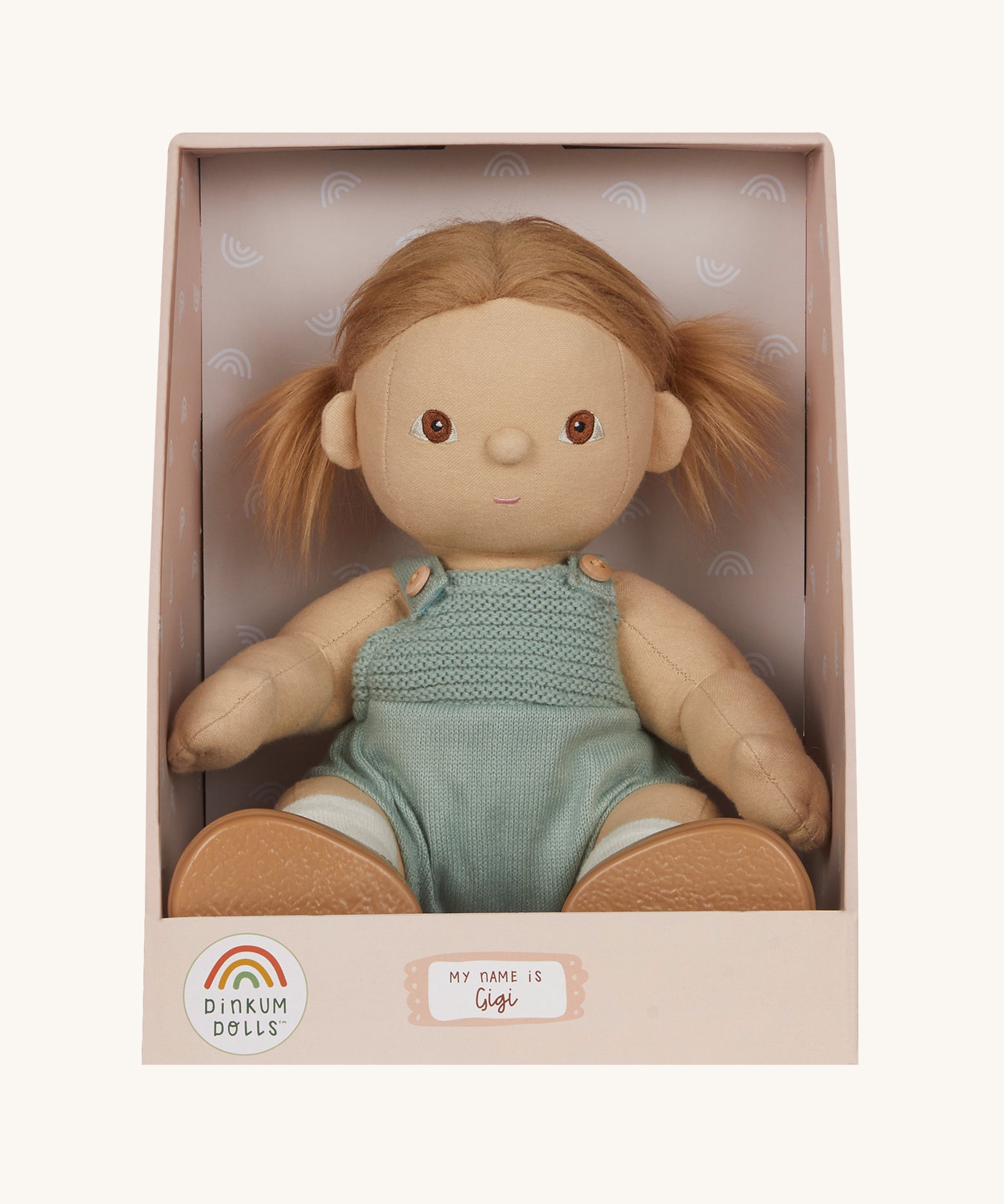 An Olli Ella Gigi Dinkum doll in a seated postion shown in it's cardboard box on a plain background. 