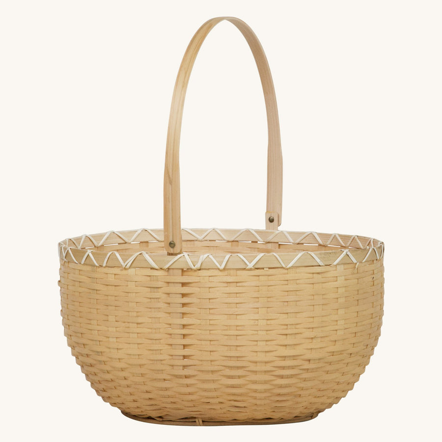 Olli Ella Nude Oval Blossom Basket with handle up pictured on a plain beige background