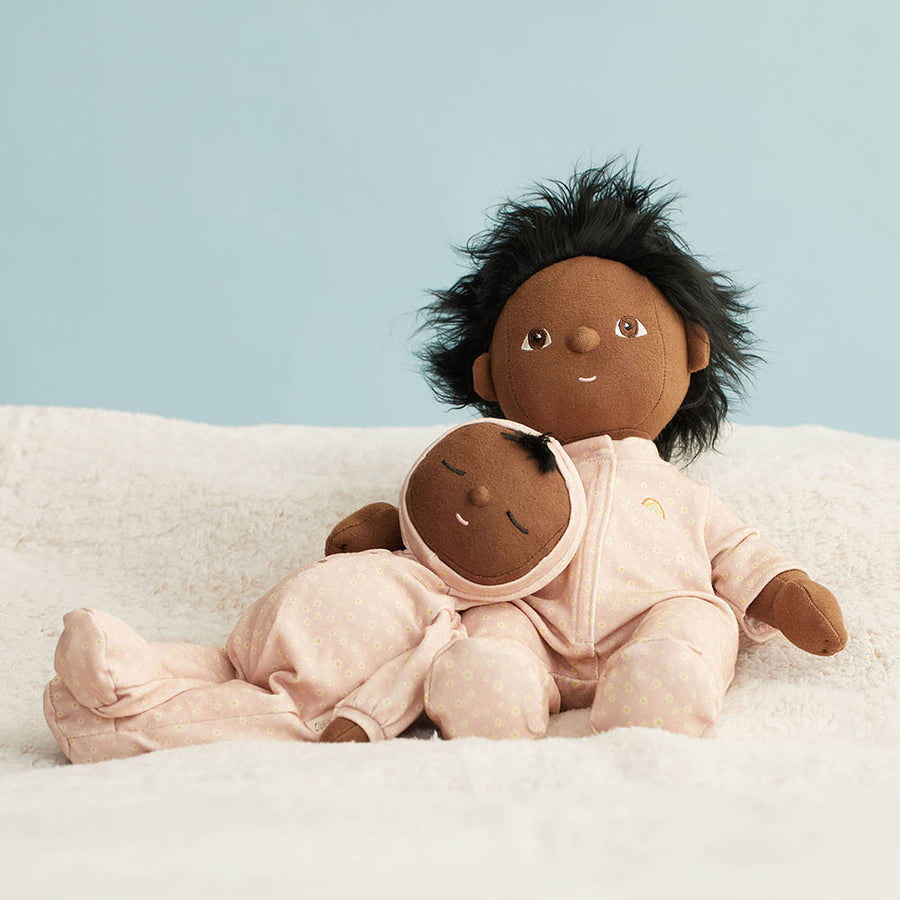 Olli Ella childrens dinkum doll and dozy dinkum laying on a white blanket wearing the pink daisy print doll pyjamas