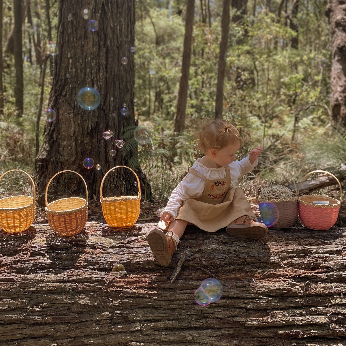 Close up of child holding 2 Olli Ella berry blossom baskets