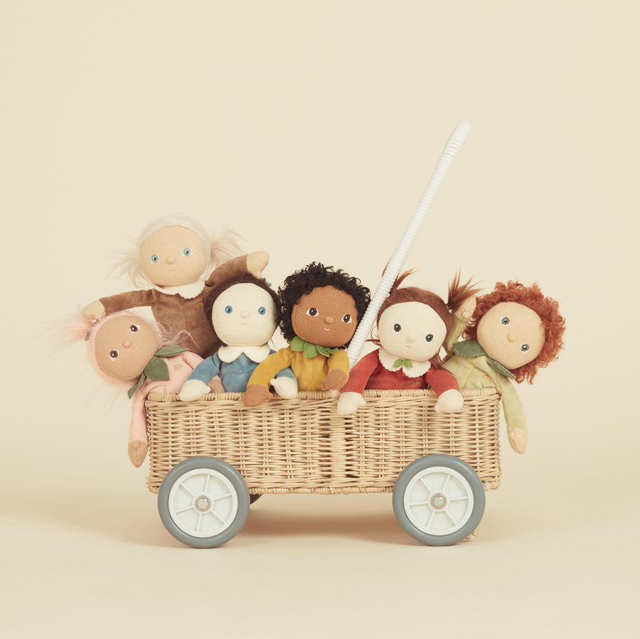 Olli Ella dinky dinkum dolls sat inside a rattan trolley on a beige background