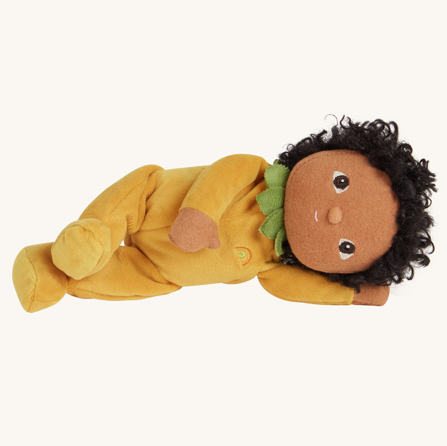 Olli Ella yellow dinky doll soft toy laying on a beige background