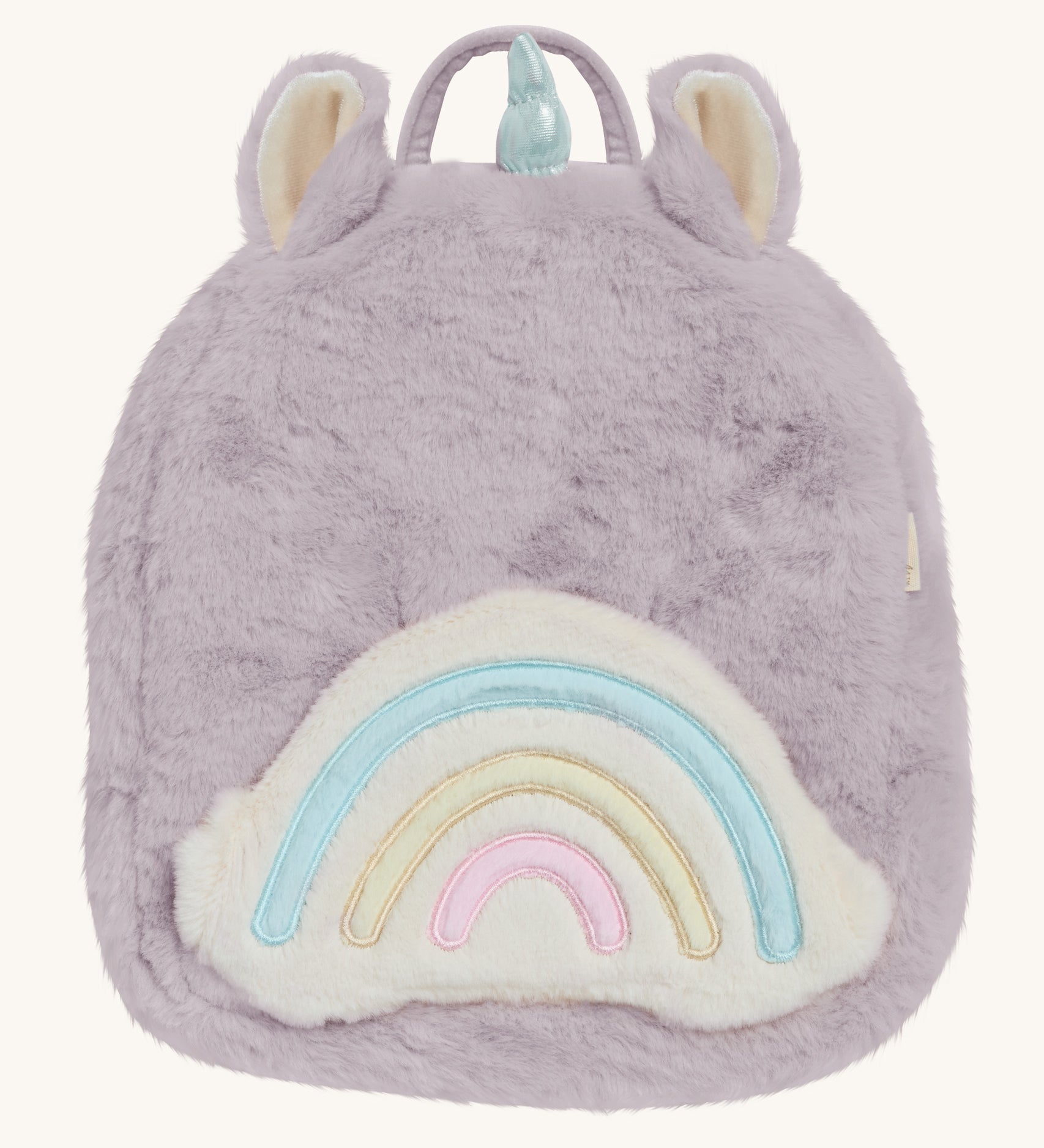  A lilac Olli Ella fluffy unicorn backpack with a rainbow on the front on a cream background.